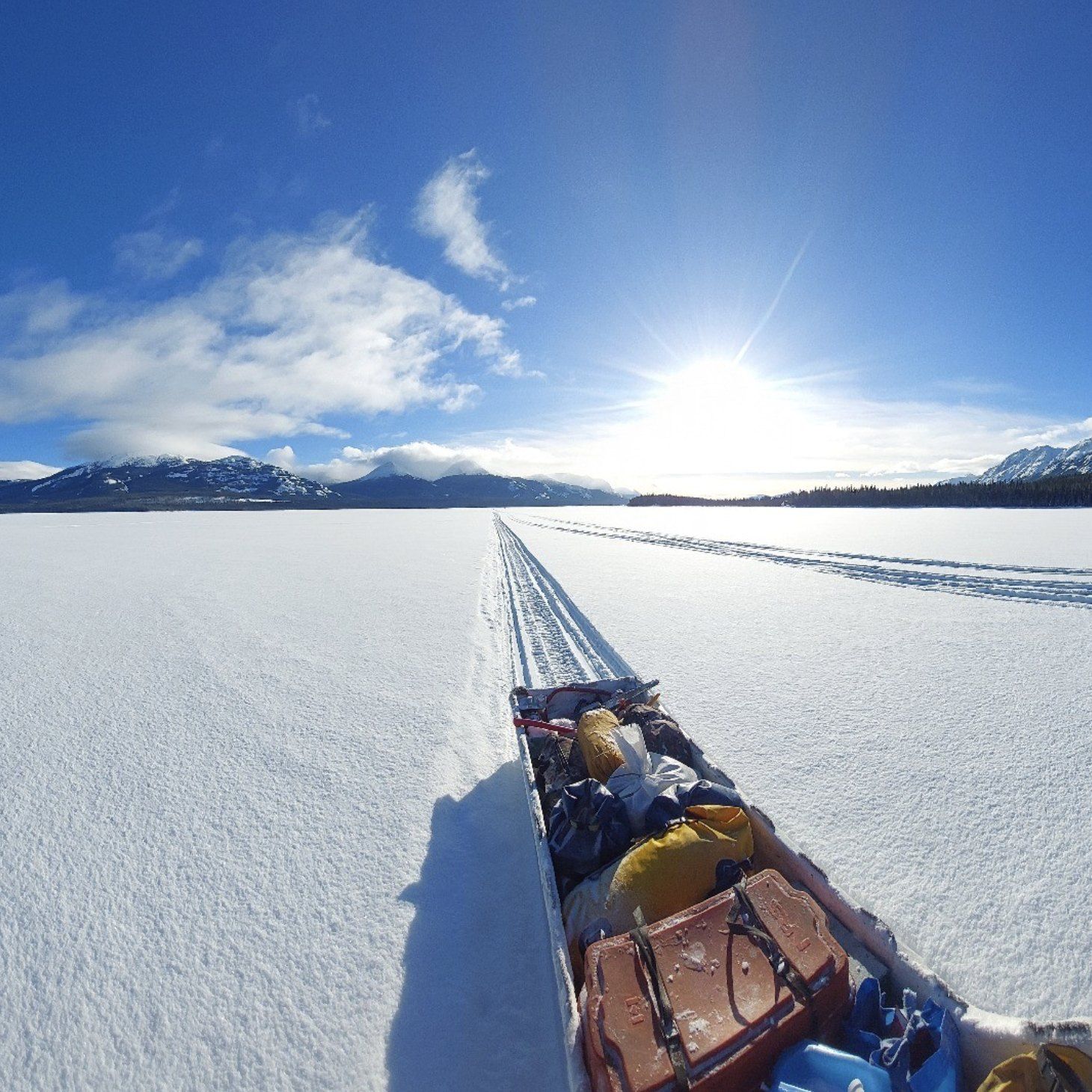 Loaded sled behind a snowmobile on a frozen lake